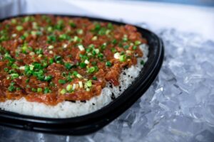 Taniokas Poke on Rice topped with green onions