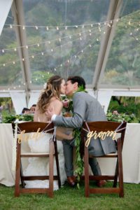 Bride and Groom Kissing While Sitting Under Tent