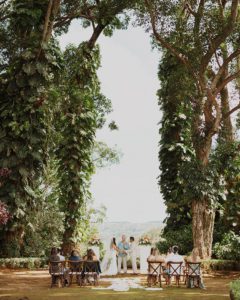 a Hawaii Wedding Ceremony, bordered by tropical trees, set up by Tropical Moon events