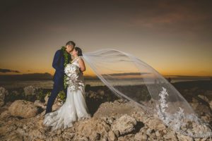 Bride and Groom sharing an invite moment during a sunset in Hawaii captured by Vivid Fotos