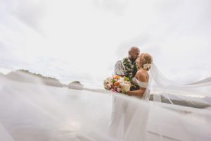 Bride and Groom Kissing with Dress Flowing in the Wind
