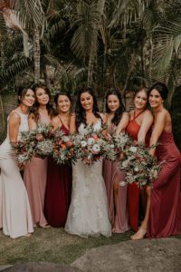 Bride and Bridesmaids Holding tropical Floral Bouquets with their hair and makeup done by Wedding hairstyles and makeup