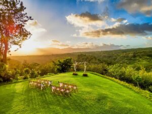 A Sunset wedding ceremony setup on a lush green lawn surrounded by lush nature