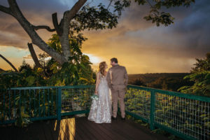 A couple sharing a romantic gaze at a wooden patio during a beautiful sunset at hawaii vista weddings venue