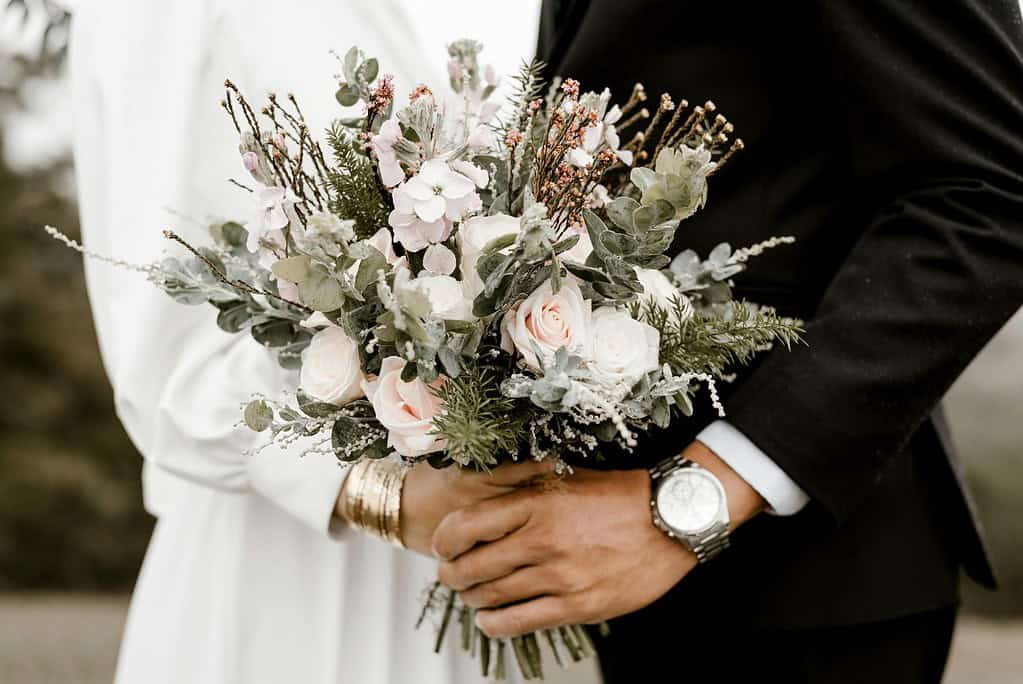 an image of wedding couple holding a bouquet