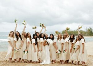 bride posing with her bridesmaids on a beach