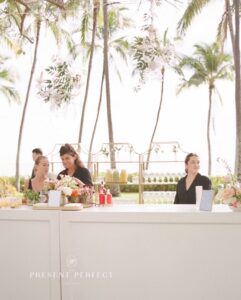 Gazoz Staff behind a white bar in an outdoor setting surrounded by Tropical Trees in Hawaii