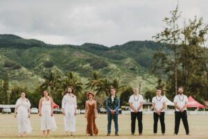 Bridal Party standing and posing for a photo against tropical mountains at Hawaii Polo Club