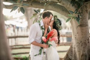 Bride and Groom Kissing under a tropical tree at Hawaii Polo Club