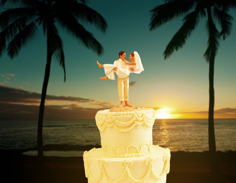White Wedding Cake with a Bride and Groom Topper against a tropical background