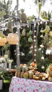 Hanging pineapple, bananas, and flowers as decor in a tropical wedding reception