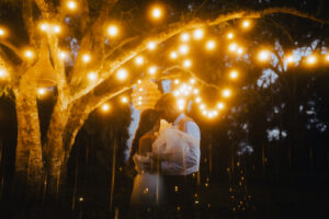 A wedding couple dancing under a tree with hanging lights captured by Seeking Films