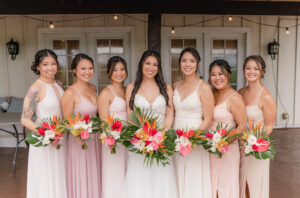 Bride and her Bridesmaids holding bouquet of tropical flowers at a wedding in Hawaii