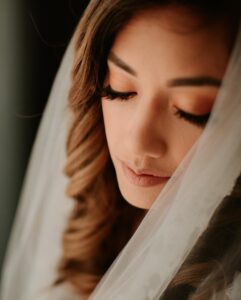 A close up of a bride wearing a veil showcasing her wedding day makeup done by Perfectly Made Hawaii