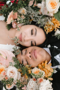 A closeup of a wedding couple surrounded by flowers by Perfectly Made Hawaii